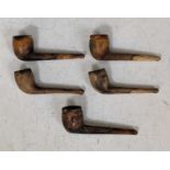A collection of five assorted vintage clay pipes.