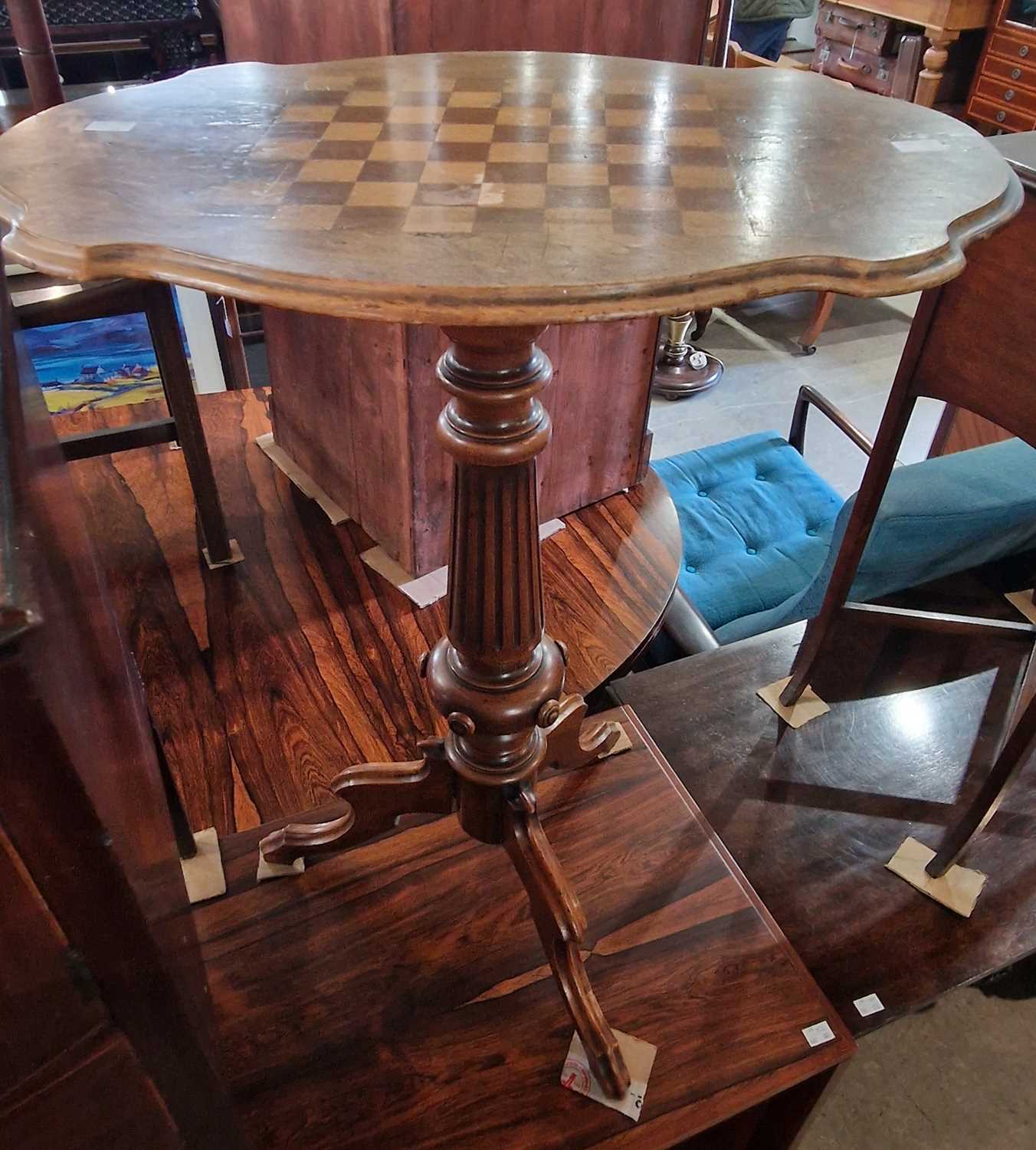 A 19th century walnut and parquetry inlaid pedestal games table, the shaped oval top centred with