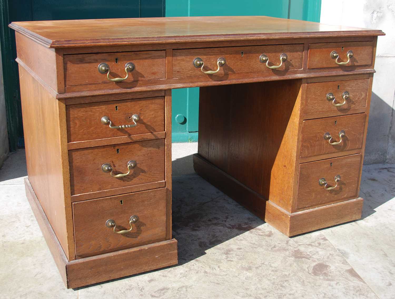 A late 19th century oak pedestal desk, the rectangular top with a moulded edge over a central frieze