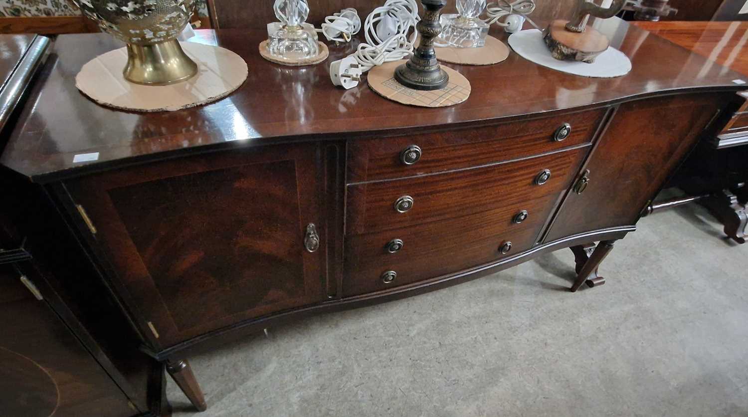 A reproduction mahogany serpentine sideboard, centred with a bank of four drawers flanked by