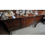 A reproduction mahogany serpentine sideboard, centred with a bank of four drawers flanked by