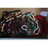 A box of assorted costume jewellery to include triple strand coral necklace, assorted stone and