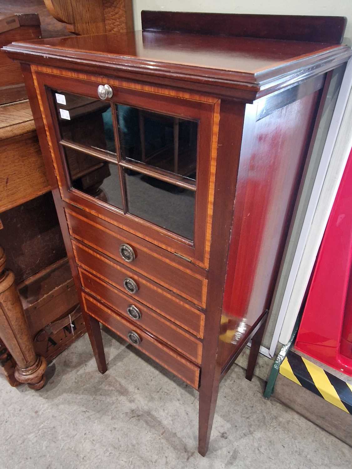 An Edwardian mahogany and satinwood banded side cabinet with glazed fall-front over four shallow