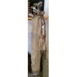 A vintage canvas and leather trimmed golf bag containing assorted hickory shafted golf clubs, to