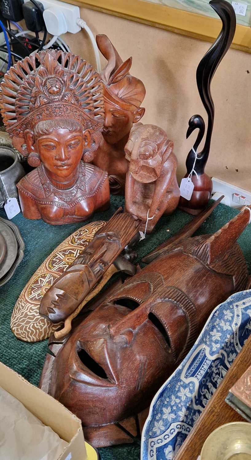 A group of nine wooden carvings to include to Balinese figural busts, various wall hangings etc.