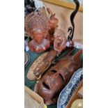 A group of nine wooden carvings to include to Balinese figural busts, various wall hangings etc.