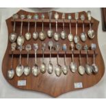 A collection of mixed Silver and EPNS Souvenir teaspoons, with various towns and crests mounted on a