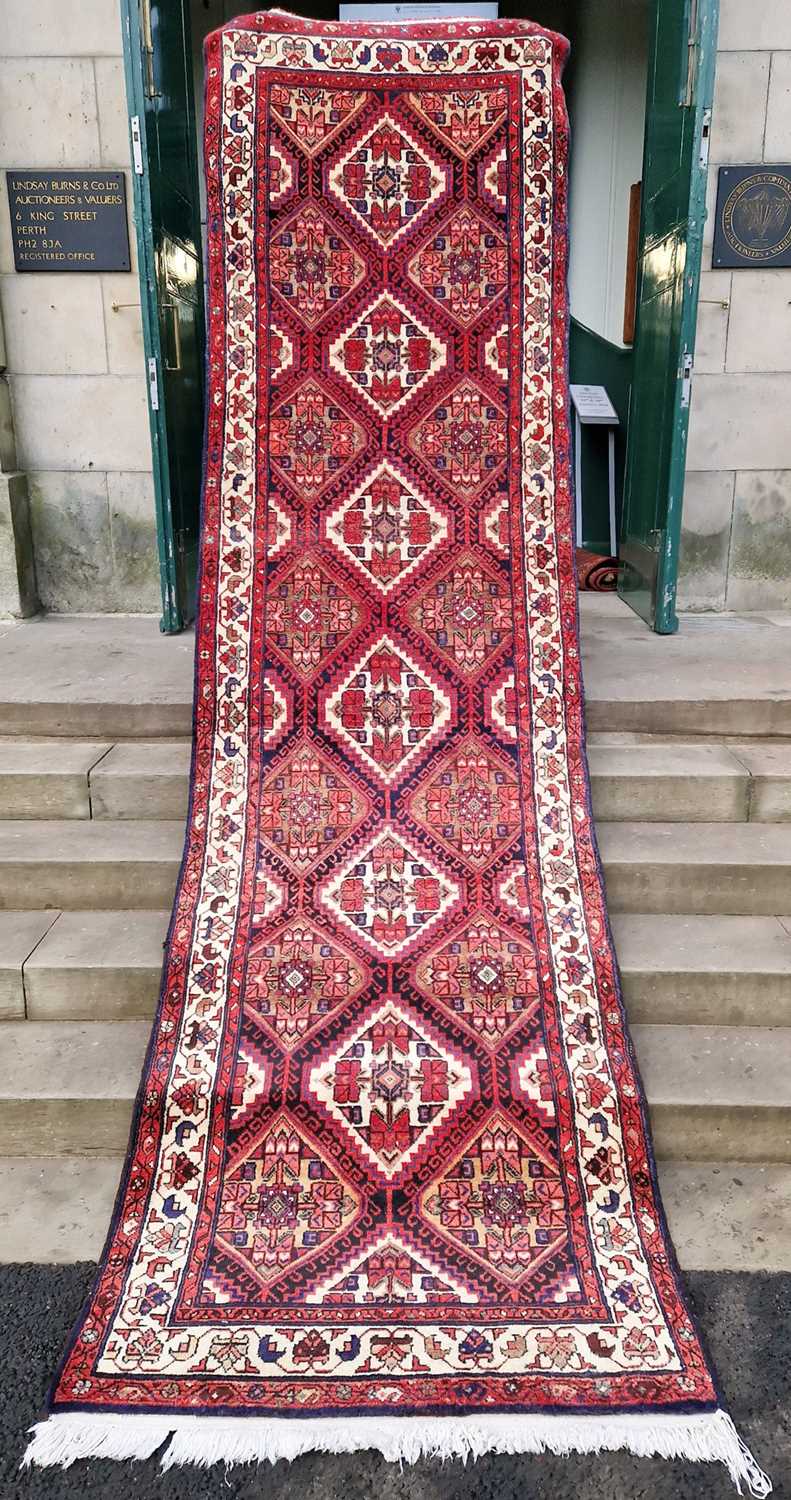 A north-west Persian long rug, 20th century, the rectangular field centred with a row of six lozenge