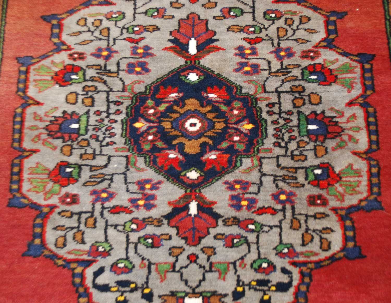 A Turkish long rug, 20th century, the rectangular abrashed madder ground centred with a large oval - Image 5 of 6