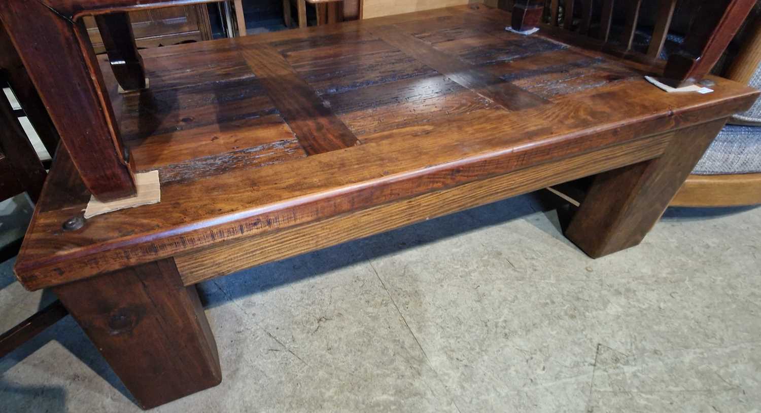 A 20th century darkwood coffee table with white metal rivet detail, 120cm wide.