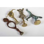 Four assorted antique brass pipe tampers, to include one in the form of a hand holding a pipe.