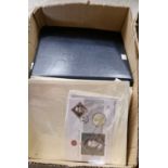 A box containing many Commemorative coin first day covers, relating to the Royal Family.