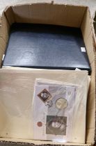 A box containing many Commemorative coin first day covers, relating to the Royal Family.