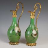 A pair of 19th century French gilt metal mounted Toleware ewers, decorated with foliate sprays on