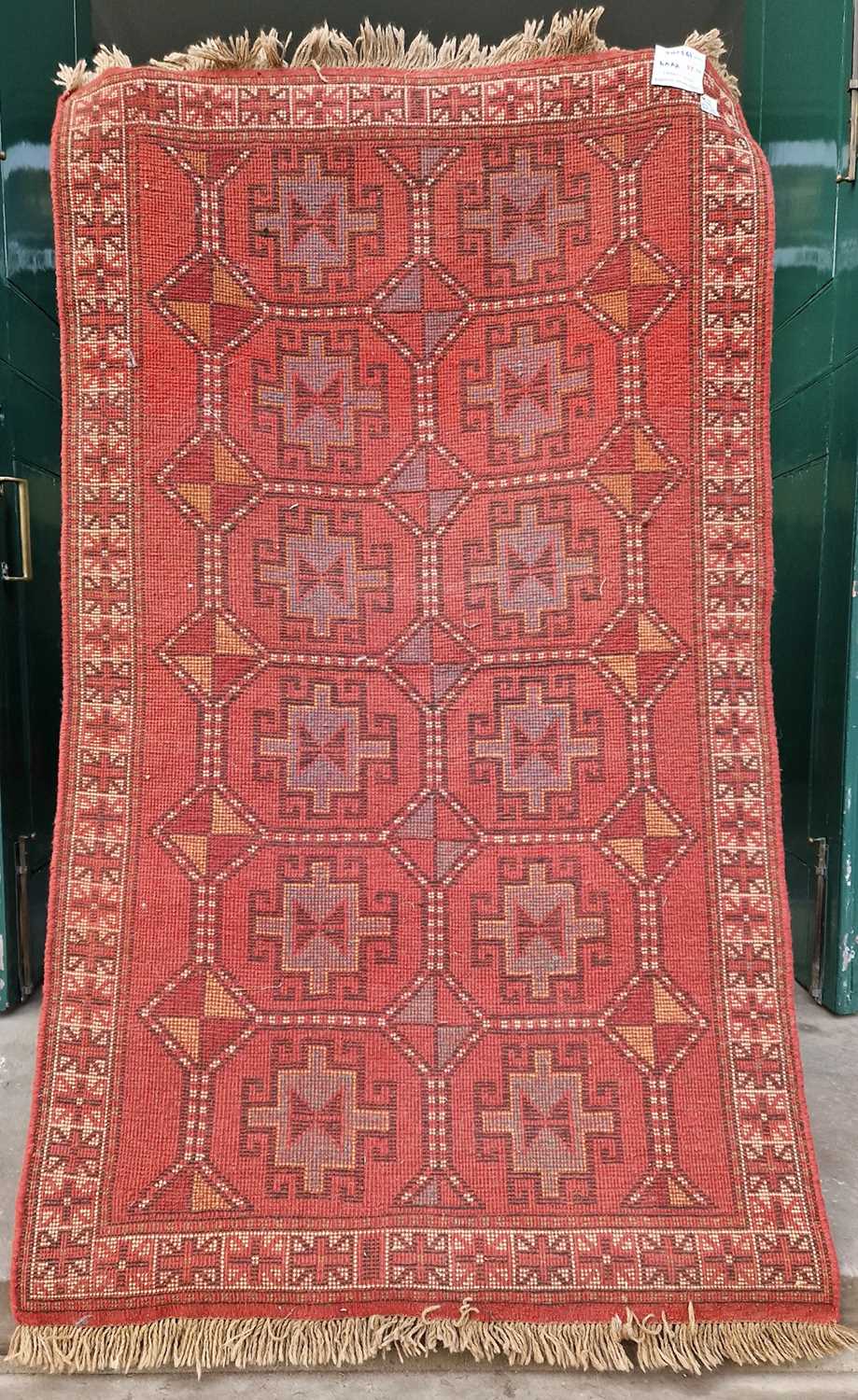 A Persian rug, Ghoochan, the rectangular madder field decorated with two rows of six octagonal - Image 2 of 5