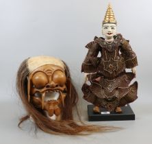 Indonesian puppet on stand together with Indonesian mask