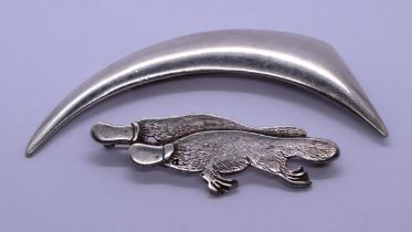 2 silver brooches - one in the form of two platypus