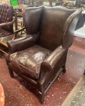 Brown leather wing back armchair