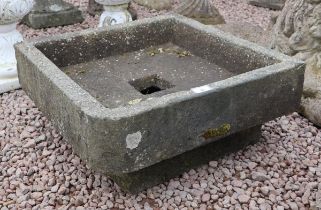 Old square stone trough on base