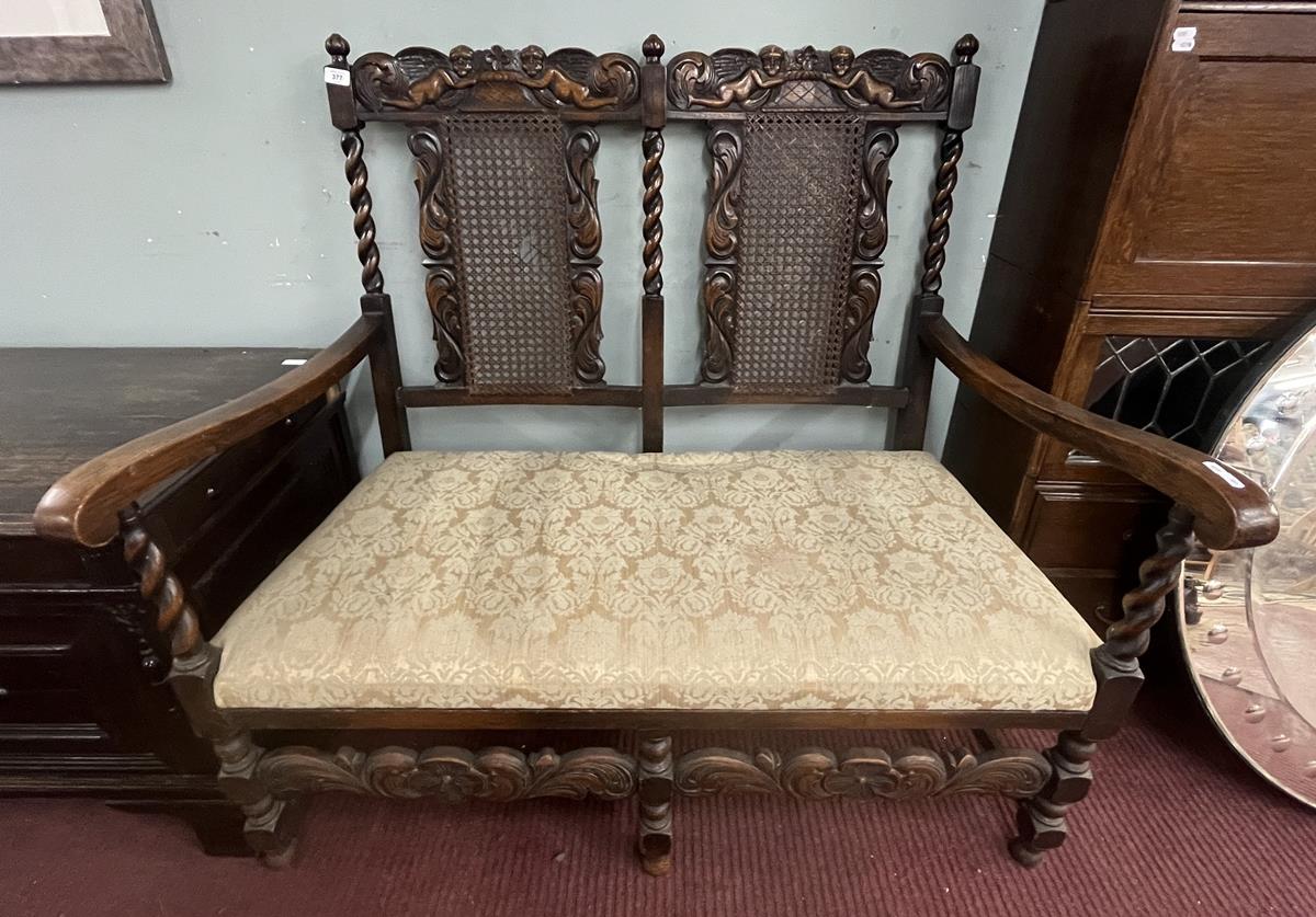 Late 19th to early 20th century Jacobean style carved rail hall bench with bergère back