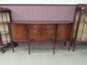 A reproduction mahogany and banded sideboard having three drawers flanked by cupboard doors on