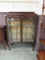 A 20th century flame mahogany glazed display cabinet, the astragal glazed doors enclosing two