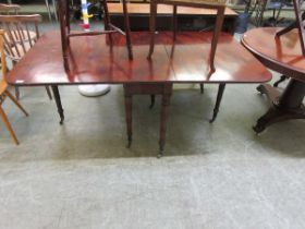 An early 19th century flame mahogany gate leg dining table on turned legs