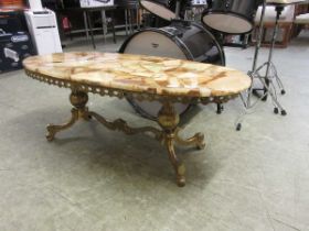 A reproduction gilt metal based table with oval simulated marble top