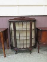 A 20th century mahogany display cabinet, the glazed door enclosing three tiers of shelving Minor