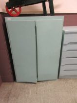 A mid-20th century style green painted two door cupboard, the doors concealing three shelves