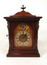 A late 19th century mahogany case mantel clock, with cast brass urn finial above the arched dial