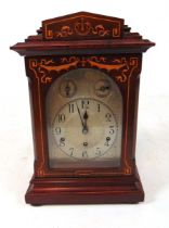 An early 20th century mahogany and inlaid mantel clock, the silvered arch dial with subsidiary