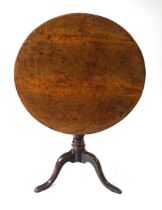 A George III burr walnut tilt top occasional table, having a well figured circular top on a vase