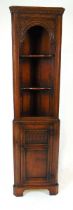 A good reproduction oak freestanding corner cupboard, of narrow proportions, with an upper section