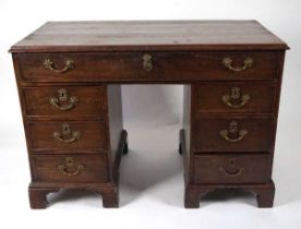 A George III mahogany desk, the top with applied moulded edge, above a long drawer fitted with a