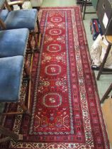 An Afghan Beshir runner, 20th century, with stylised motifs on a red ground with numerous borders,