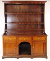 An 18th century oak welsh dresser, with moulded pediment above a boarded back with three shelves,