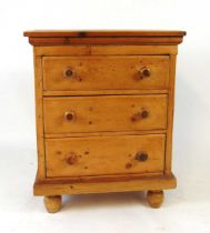 A stripped pine three drawer chest, 19th century and later, with turned bun handles and feet, 68.5cm