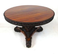 An early 19th century rosewood breakfast table, with beaded edge over a frieze of applied carved