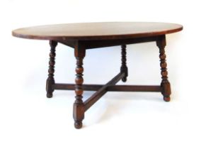 A reproduction oak dining table, having a well figured oval top on a fixed base with bobbin turned