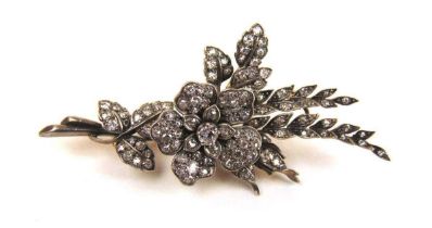 An early 20th century yellow and white metal diamond splay brooch with tremblant flowerhead. The