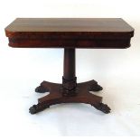 An early 19th century rosewood card table, with turn over top, on a plain column with tongue