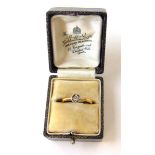 An early 20th century yellow metal and diamond solitaire ring marked '18ct', the small stone in an