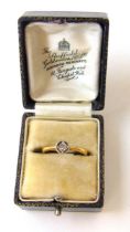 An early 20th century yellow metal and diamond solitaire ring marked '18ct', the small stone in an