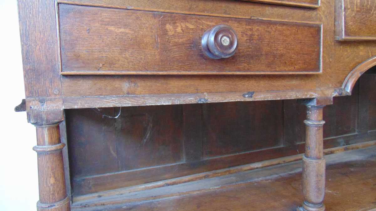 An 18th century oak dresser, with moulded pediment over three shelves and iron hooks, the base - Image 4 of 9