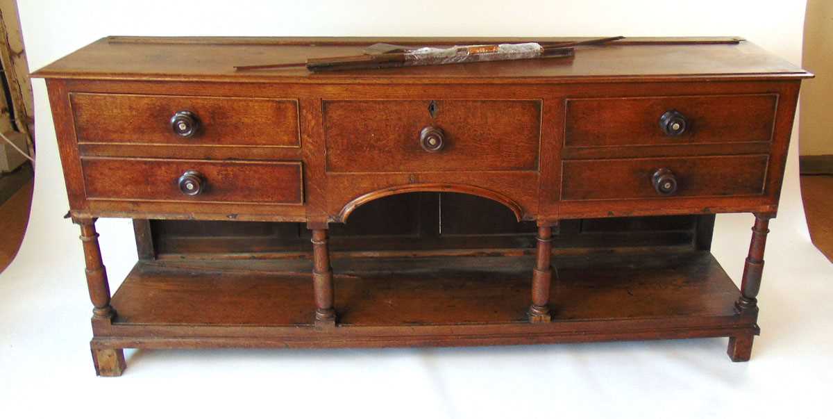 An 18th century oak dresser, with moulded pediment over three shelves and iron hooks, the base - Image 2 of 9