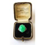 An Art Deco white metal and cabochon jade ring marked '18ct'. Size H. Approx. weight 4.7g With box
