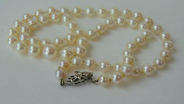 A string of cultured pearls having a 9ct white gold clasp set with a diamond chip, l. 54 cm