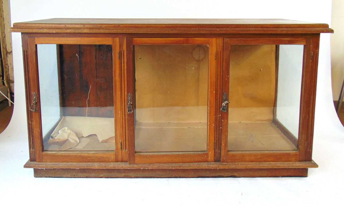 A Victorian mahogany shop display counter, the top with applied moulded edge above three glazed