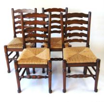 A set of four reproduction oak ladderback dining chairs, with drop in rush seats, 97.5cm high